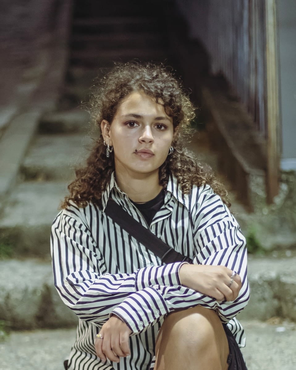 Si sociologe, gjithmonë kam dashur që ta përdor filmin si medium, por shtytësi që ma ka jep atë kurajon dhe vetëbesimin për t’i hyrë kësaj fushe pa përvojë paraprake kanë qenë dy punëtori, njëra e DokuFest në 2022 dhe tjetra e Kino ARMATA, programit Neo School.<br />
Mendoj se regjisorët më të mirë janë ata që jodomosdoshmërisht kanë prapavijën vetëm në filml, por ata që i përmes një fushe tjetër të përvojës, e sjellin atë dije në skenën e filmit.<br />
Para se me dalë në xhirime, ti veç e ke një ide se qysh don me u dokë filmi, por pa dalë në terren, pa i marrë pamjet nuk e di se cilat elemente do të bashkohen. Ekipi im me të vërtetë ka qenë i mrekullueshëm dhe bashkëpunimi ka qenë perfekt. Një nga vështirësitë ishte afati kohor, se e kemi pasë vetëm një ditë për xhirime, por edhe kjo e ka bërë edhe më të bukur, sepse përkundër vështirësisë së kohës ia arritëm.