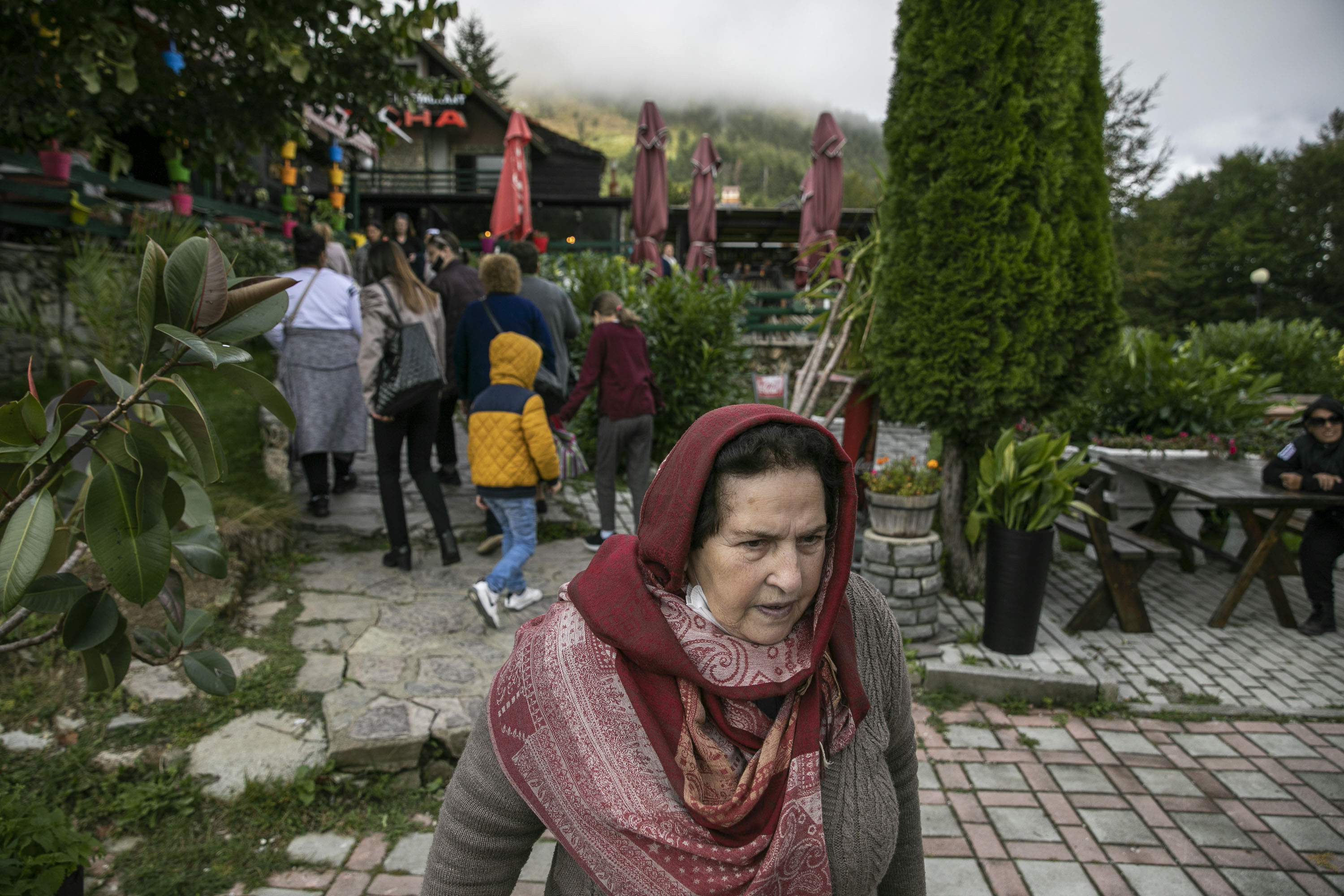 An elderly woman at the entry of a restaurant at the Prevalla Pass during an organized bus tour for the women of Prishtina.