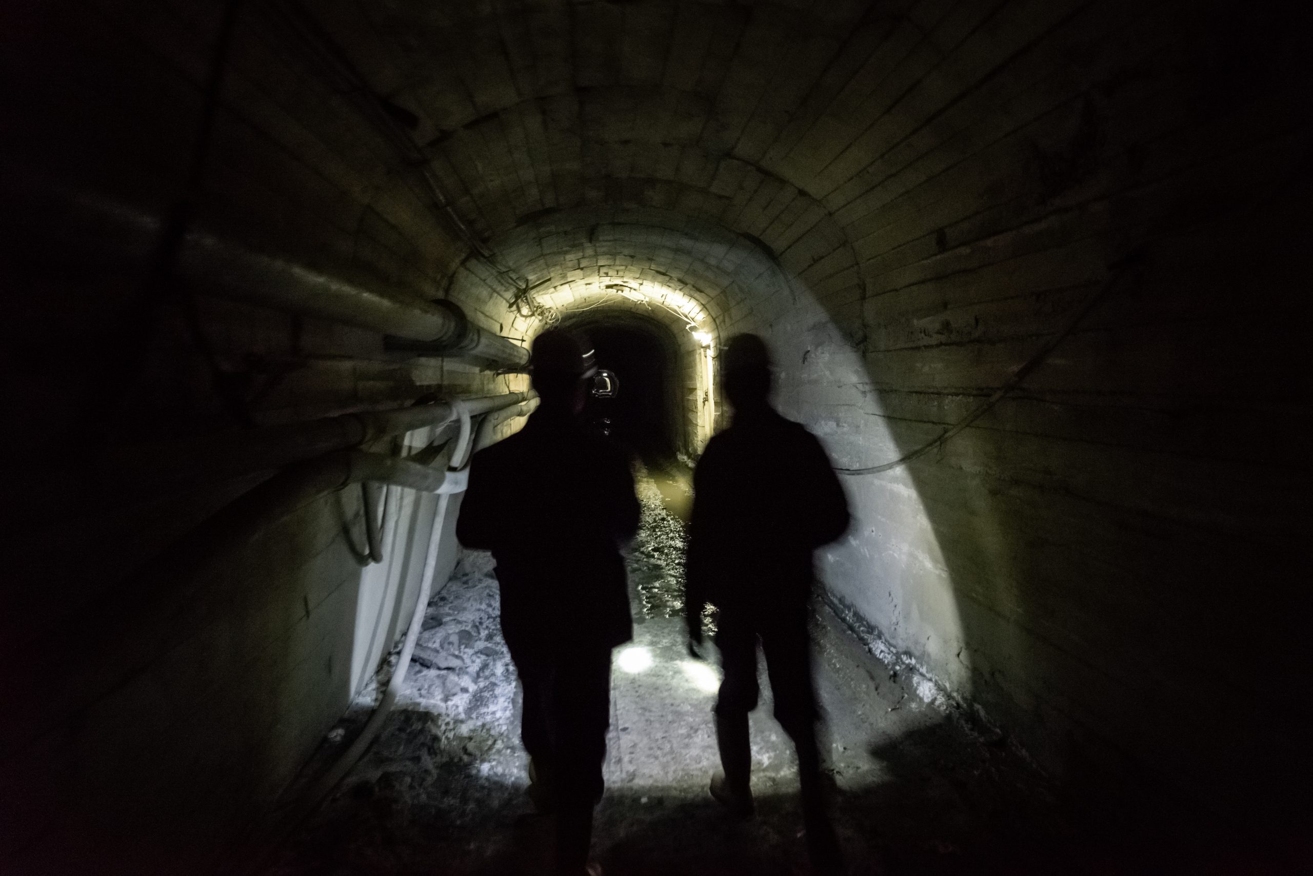 Punëtorët dhe inxhinierët duke ecur në një galeri minerare në nivelin e dhjetë nëntokësor të Trepçës në Stantërg.