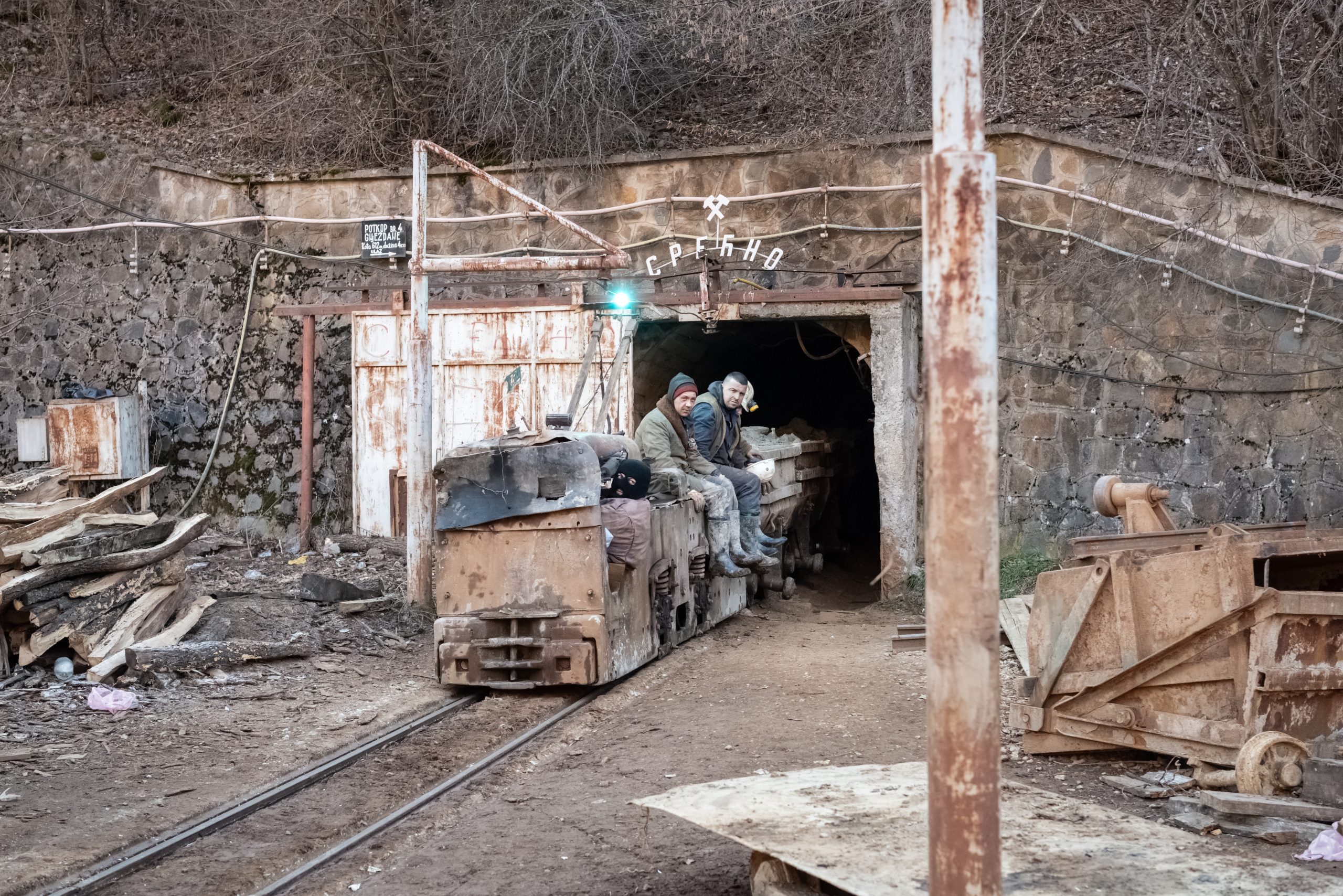Miners on a convoy of wagons exit the mine entrance after the morning shift at the Trepça mine site in Crnac.