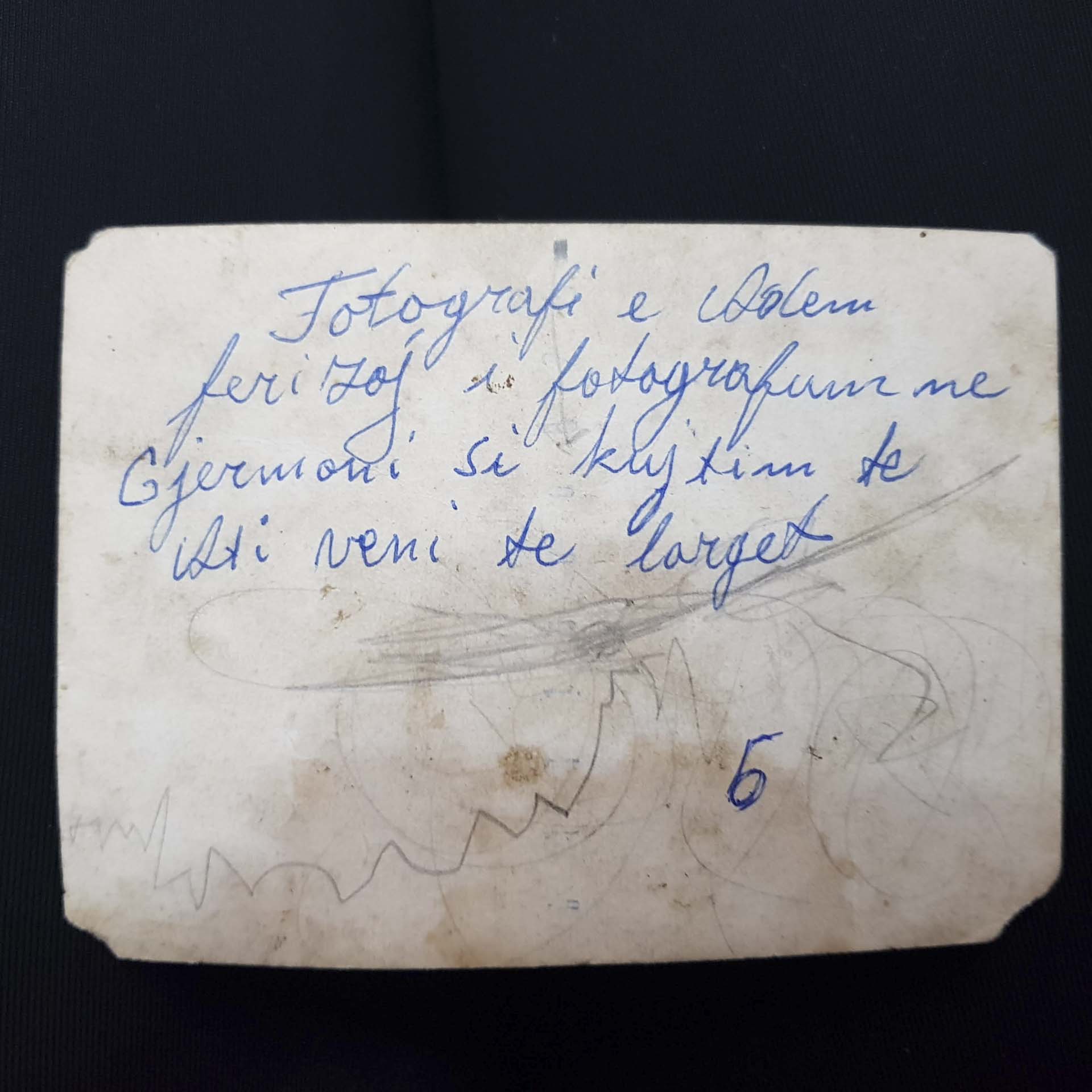 A handwritten annotation appears on the back of an old photo.